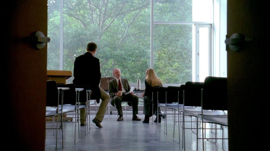 Olivia and Peter talk to Dr. Penrose in his classroom.