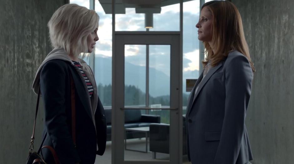Liv and Vivian talk outside the classroom in front of a window.