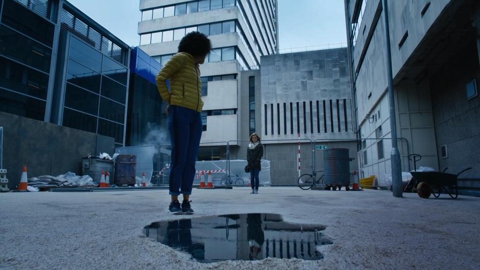 Bill looks towards Heather from where she is standing in front of the mysterious puddle.