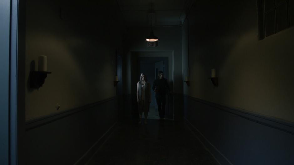 Alice and Quentin look down the recently darkened hallway.