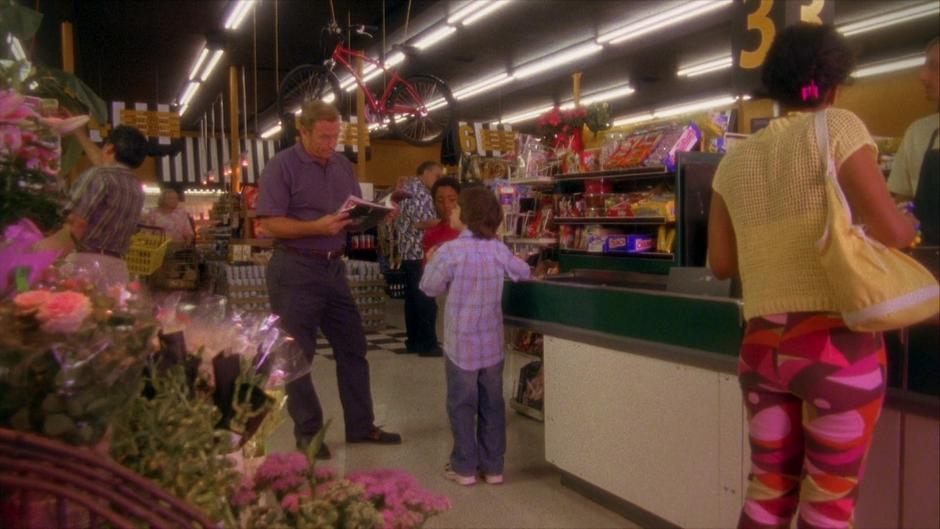 Shawn asks for more money to buy an extra candy bar from his father while Gus stands with his own supply.