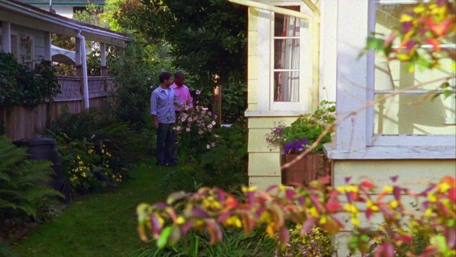 Gus and Shawn walk down the side of Hugo's house looking for clues.