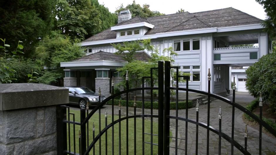 The mansion sits behind a tall imposing gate.