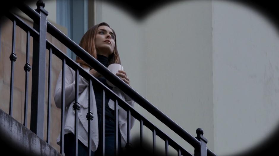 Natalie is visible on the balcony through Major's binoculars.