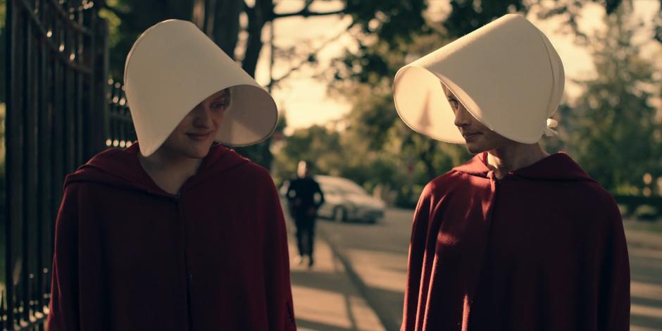 Offred and Ofglen share a smile as they walk back to the gate after the execution.