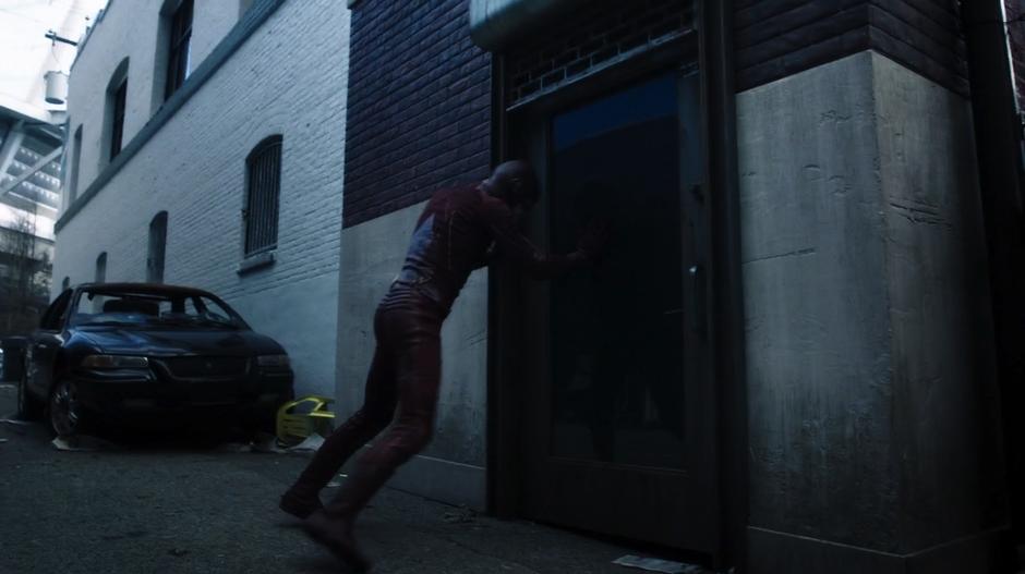 Barry leans against the wall as he is being incapacitated by Top's powers.