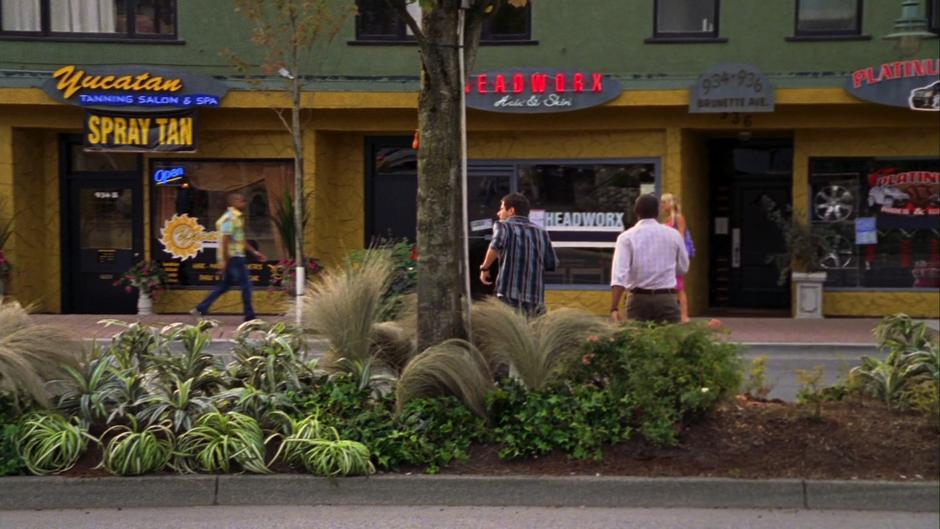 Shawn and Gus cross the street towards the front of the salon.