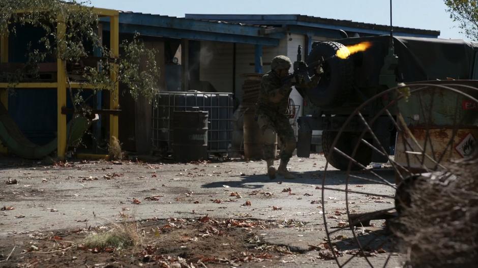 Justin provides covering fire on the rooftop while running away from the Humvee.