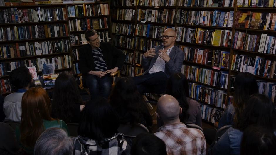 Two authors speak in front of a group of people in the corner of the store.