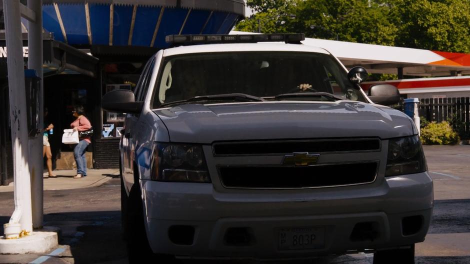 Diego pulls his police SUV into the parking lot of the hot dog place with Riley in the passenger's seat.