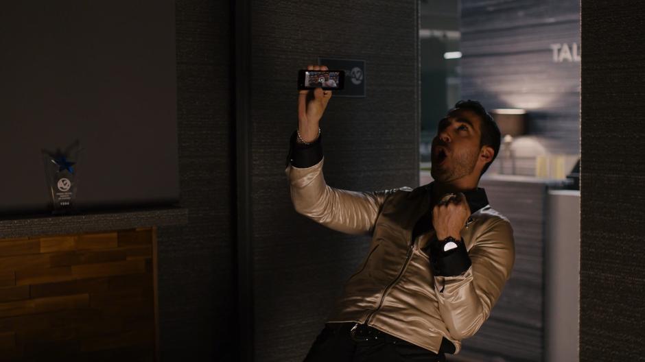 Lito celebrates while holding up the video of him from pride.