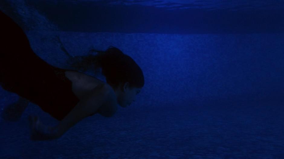 Kala dives underwater in the moonlit pool.