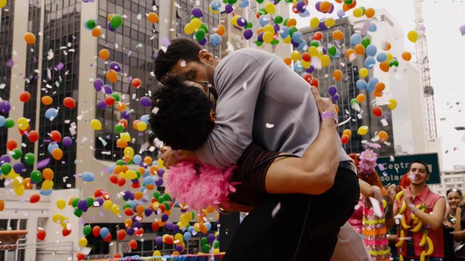 Lito dips Hernando down for a kiss while they are surrounded by balloons and confetti.