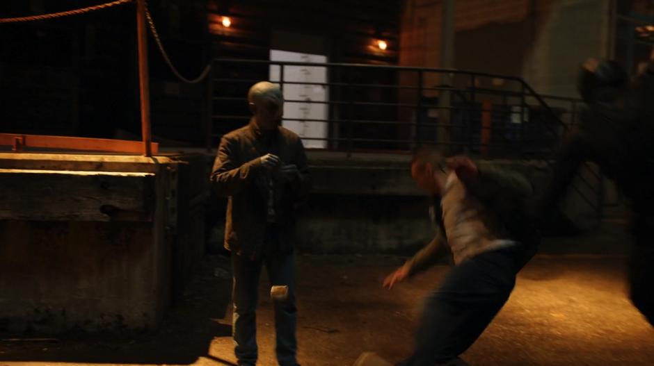 James knocks down the drug dealer while Brian watches.