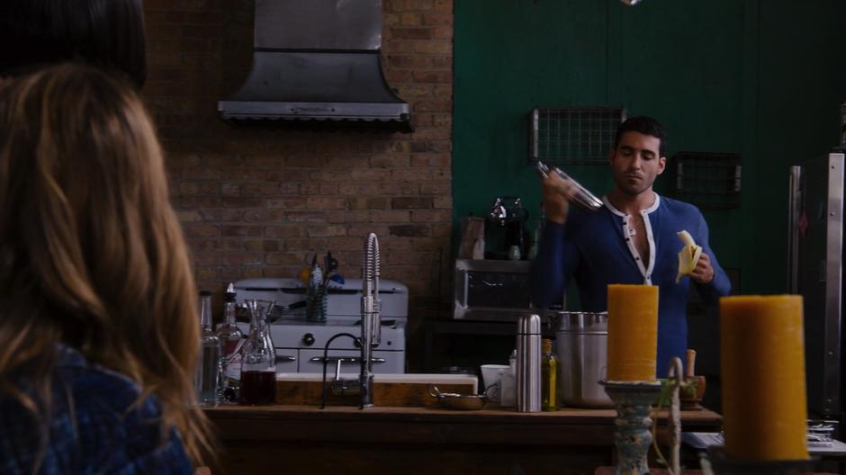 Nomi looks at Lito who is showing off his flare bartending skills while dressed in a onesie.