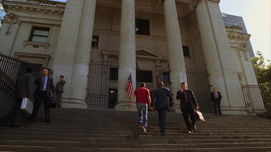 Shawn and Gus walk up the stairs of the courthouse so Shawn can pay a parking ticket.