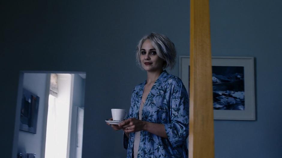 Riley in the place of Whispers's wife walks up to the bed with a morning coffee.