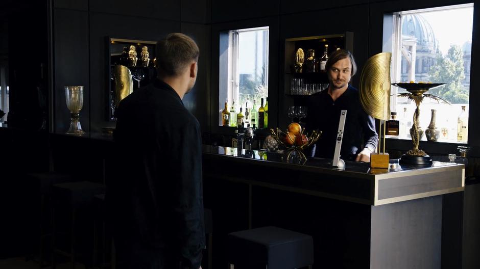 Sebastian Fuchs offers Wolfgang a drink from the bar.