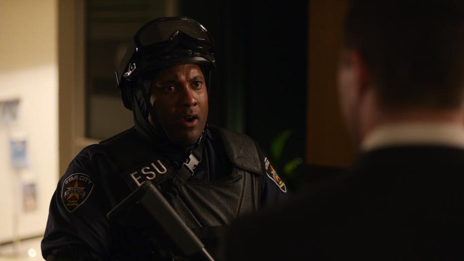 A police officer approaches Oliver and Lance to tell them about the suspicious package.