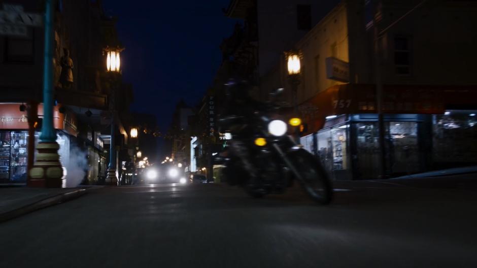 Amanita turns onto the street on her motorcycle.