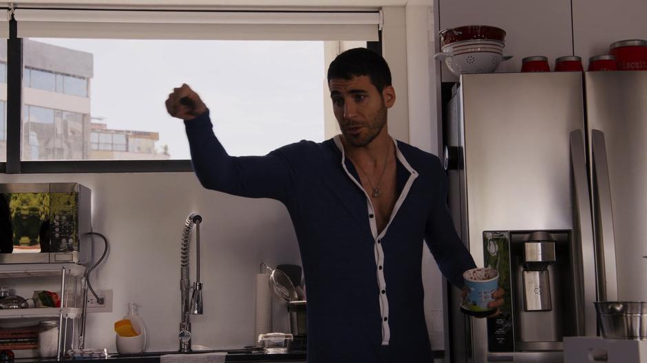 Lito gestures to the others while standing in the kitchen with his tub ice cream.