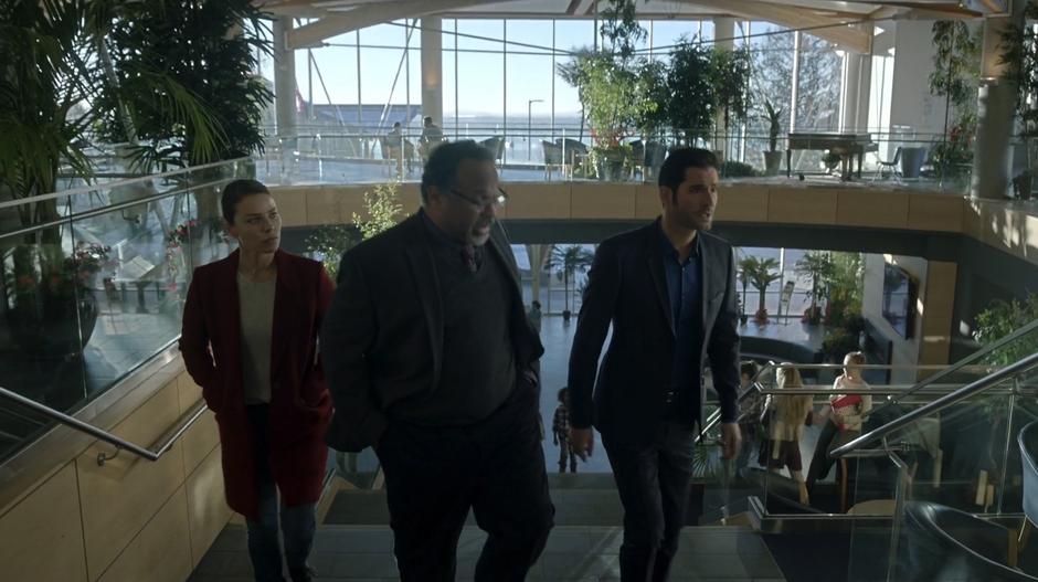 Chloe and Lucifer walk up the stairs with the headmaster while he tells them about the school.