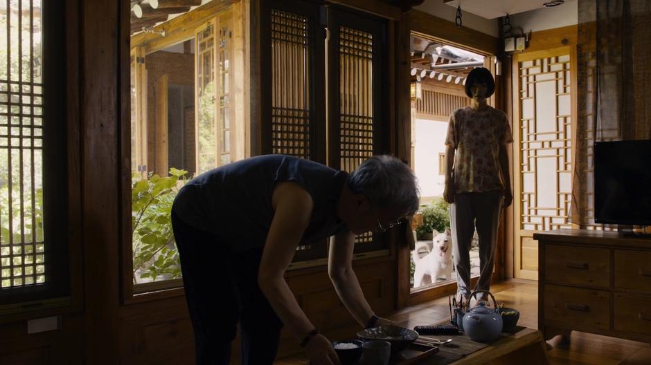 Sun enters the home as her teacher is setting out a meal.