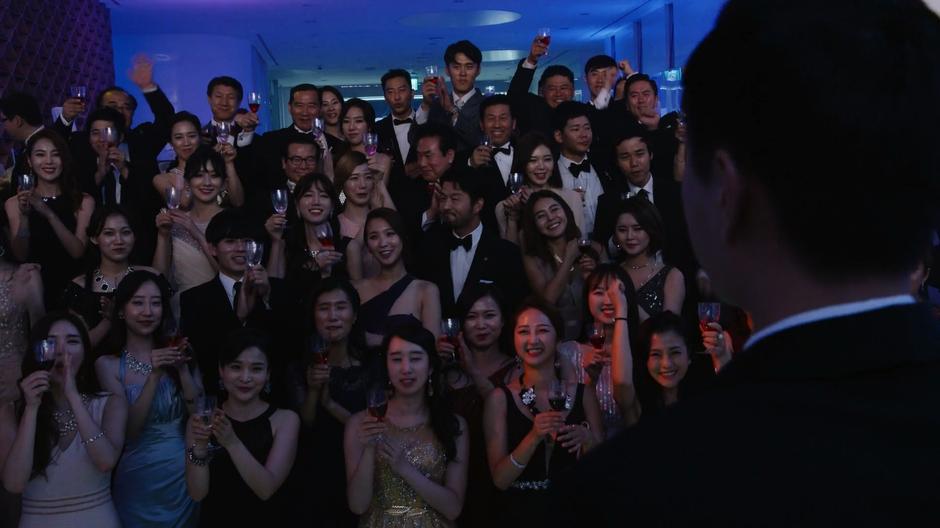 People raise their glasses at the end of Joong-Ki's speech.
