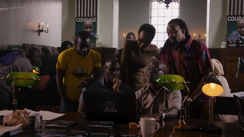 Capheus, Jela, and the campaign team review the propaganda released by their opponent.