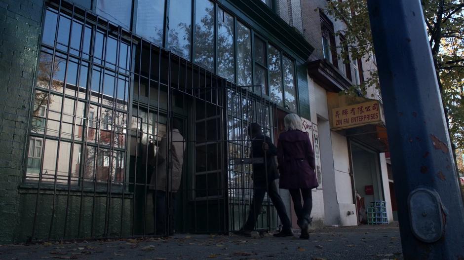 Coleman Baker leads Clive and Liv into his offices.