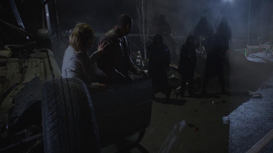 Felicity and Diggle climb out of the crashed car and find themselves surrounded by Talia's goons.