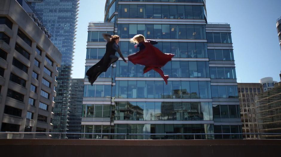 Rhea and Kara leap at one another as the combat begins.