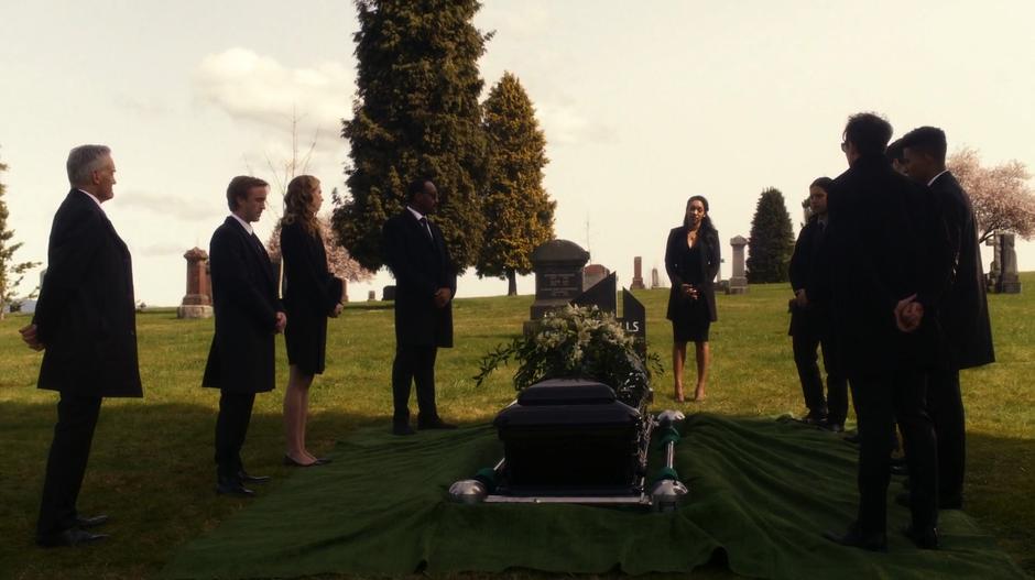 Iris delivers her eulogy while the whole group stands around H.R. coffin.