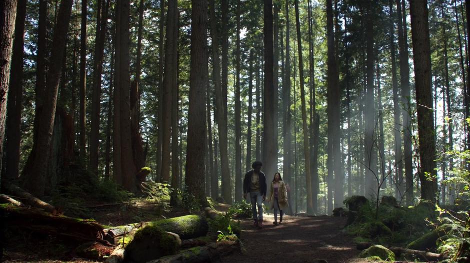 Curtis and Samantha walk together through the woods.