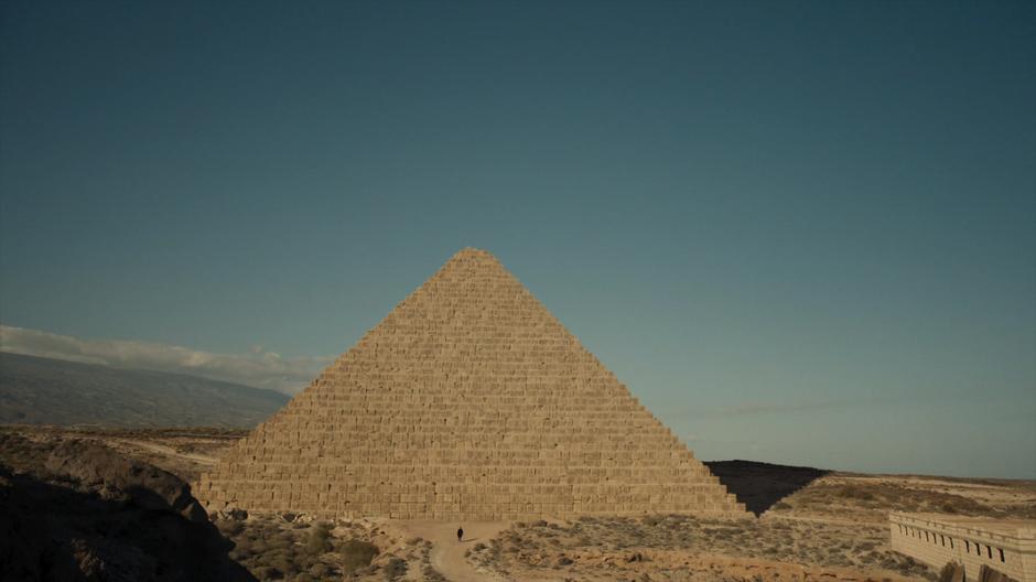 The Doctor walks up to the front of the giant pyramid.