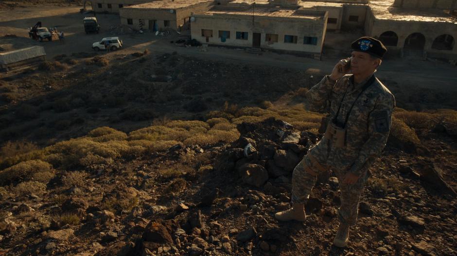 Colonel Brabbit talks to the Secretary General on the phone while looking at the pyramid from atop a nearby hill.