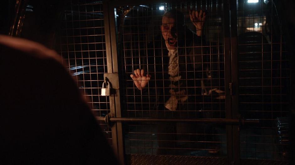 Don E in full-on-zombie mode attacks the door of the cage in the back of the van.