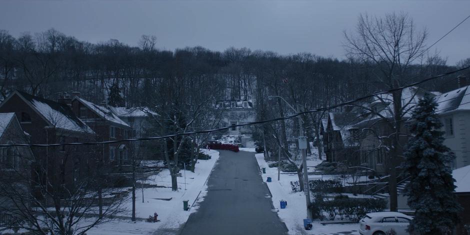 The handmaids walk around the corner down the snowy street.