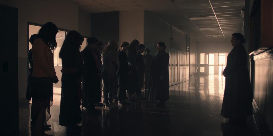 Aunt Lydia addresses the new group of handmaids as they stand in a line.