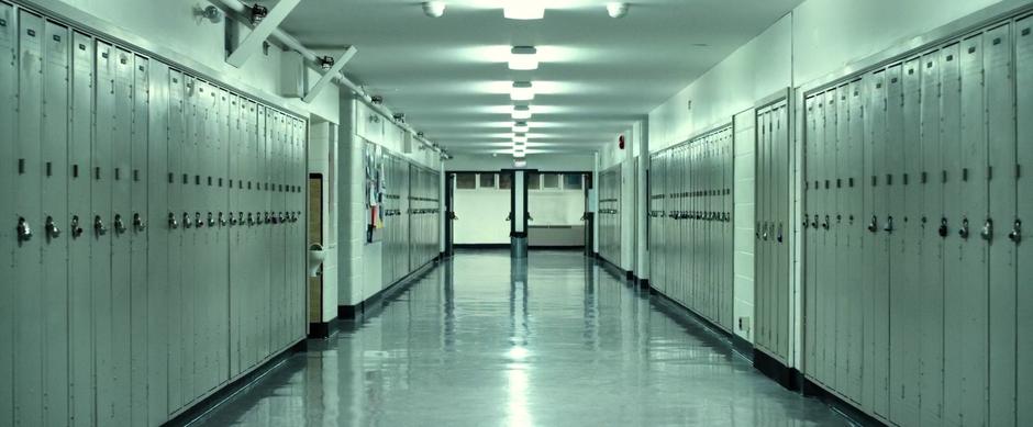 A view down the school hallway just before a locker explodes.