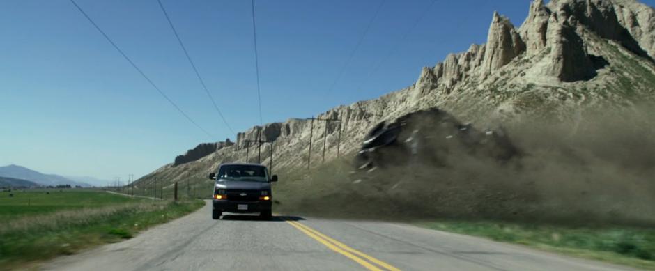 Zack's Zord slides across the road behind the van.