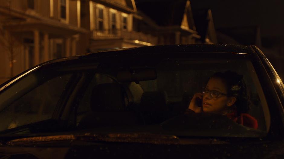 Cosima talks to Beth on the phone in her car while looking up at the Hendrix house.