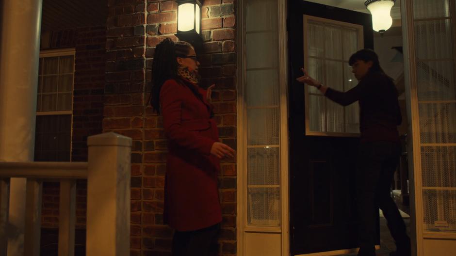 Alison points at Cosima while backing through her front door.