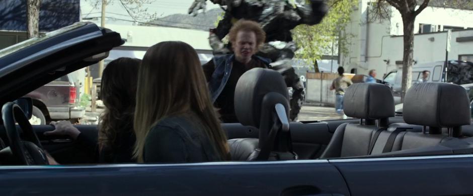 The school bully runs towards Amanda & Harper's car while being chased by a Putty.