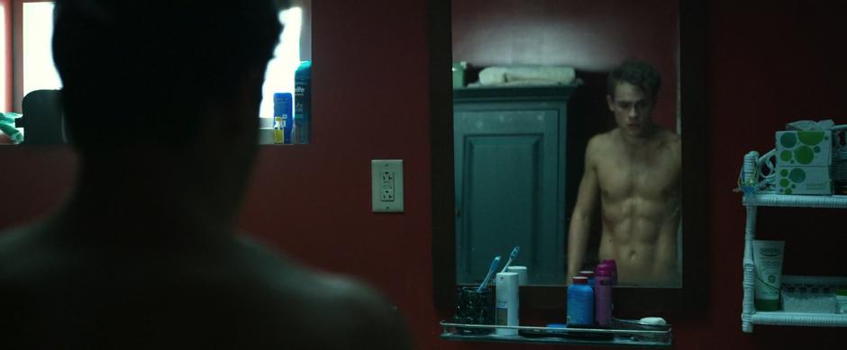 Jason walks into the bathroom shirtless and sees his power coin waiting for him on the edge of the sink.