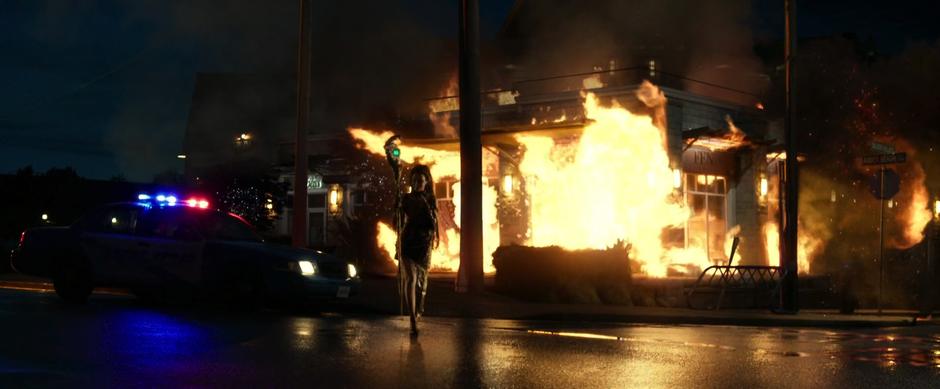 Rita walks away from the store with a joyful look on her face as the store is engulfed in flames.