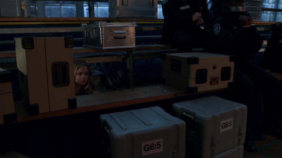 Liv watches the mercenaries from underneath the bleachers.