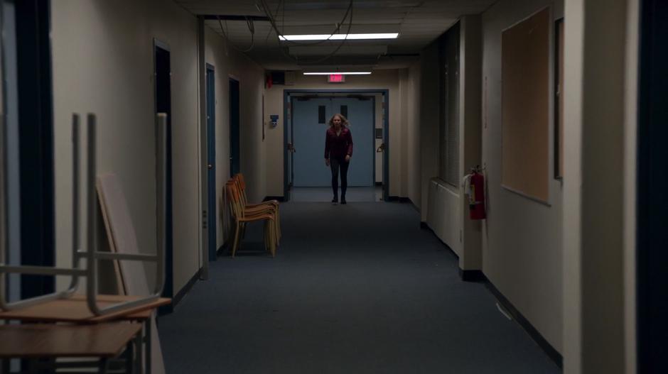 Liv walks down the hallway after sneaking out of the gymnasium.