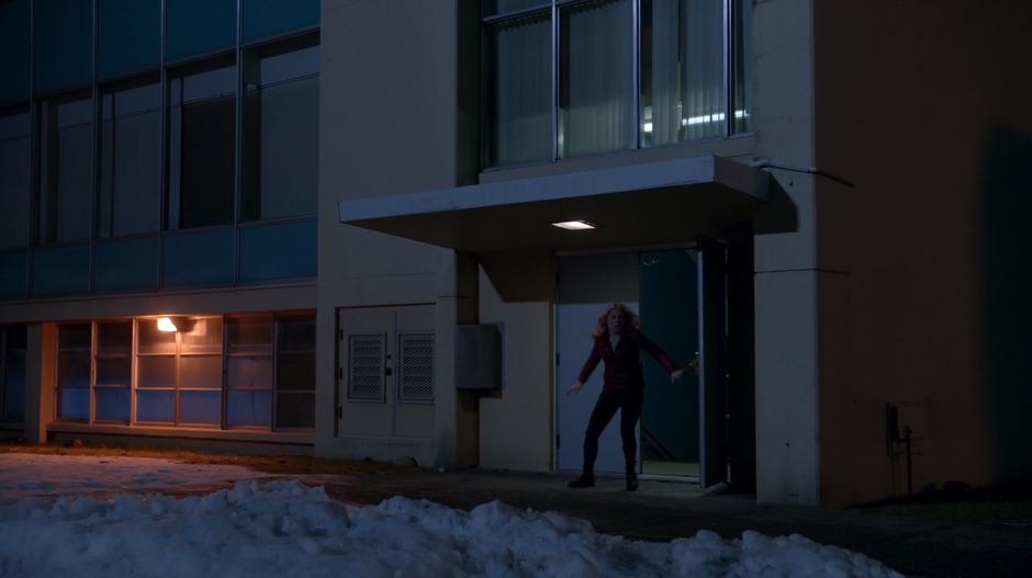 Liv bursts out of the school while running from the mercenaries.
