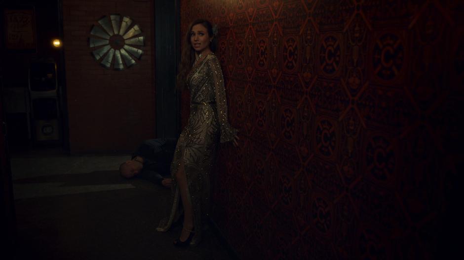 Waverly looks down the hallway at Wynonna while the body of the buyer lies on the ground behind her.